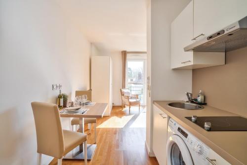 - une cuisine et une salle à manger avec une table et un évier dans l'établissement OVELIA Chatou - Le Carré Brimont, à Chatou