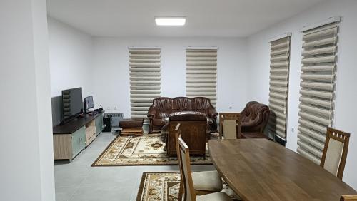 a living room with leather chairs and a table at Grand Apartman in Živinice