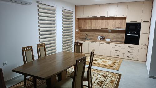 a kitchen with a wooden table and chairs in it at Grand Apartman in Živinice