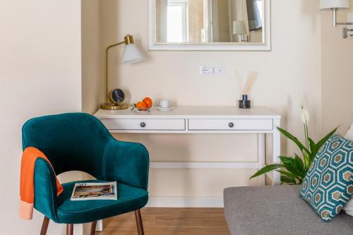 Momo Central Rome 2 في روما: غرفة معيشة مع كرسي أخضر ومكتب