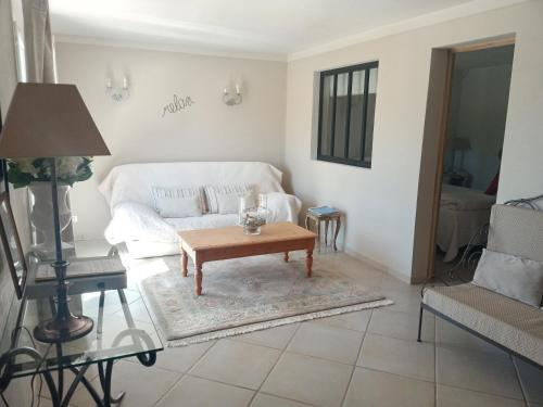 Sala de estar con sofá blanco y mesa de centro en Le Grand Barsan, en Vaison-la-Romaine
