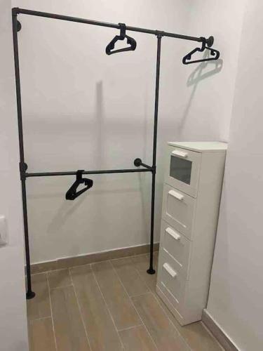 a room with a white wall with a shelf and a refrigerator at Planta baja moderna y nueva a estrenar en el centro ciudad 2 habitaciones y 2 baños in Elche