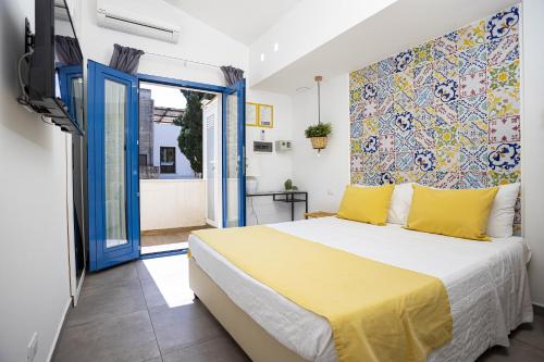 a bedroom with a bed with a yellow bedspread at Acquarò Suite in San Vito lo Capo