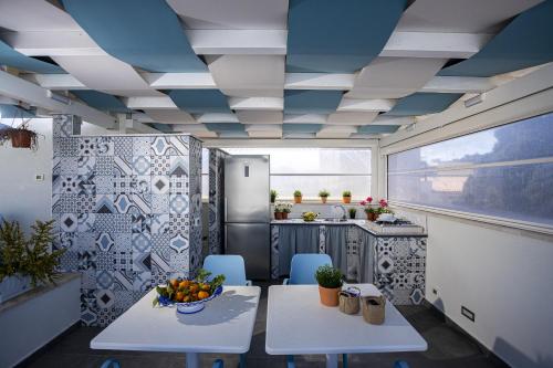 a kitchen with a table and a bowl of fruit at Acquarò Suite in San Vito lo Capo