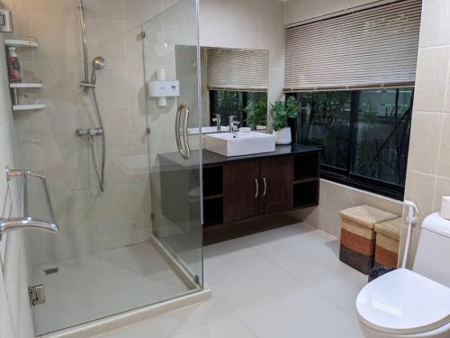 bagno con doccia, lavandino e servizi igienici di The Sands beach apartment a Nai Harn Beach