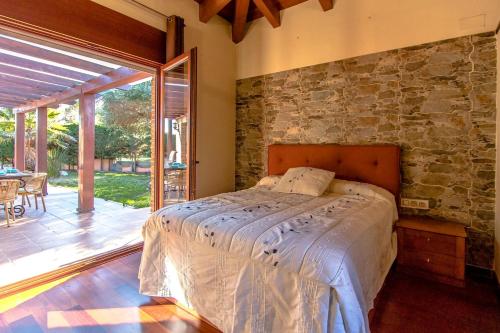 1 dormitorio con cama y pared de piedra en Catalunya Casas A Costa Brava gem - only a few minutes to the beach!, en Vidreres