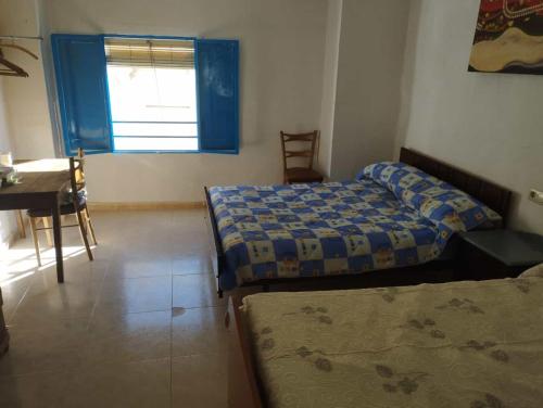1 dormitorio con 2 camas, escritorio y ventana en La Casa los Trancos, muy cerca de Cazorla, en Peal de Becerro