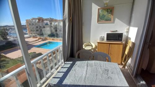 Cette chambre dispose d'un balcon avec une table et un four micro-ondes. dans l'établissement Studio-cabine Port Dauphin, au Cap d'Agde