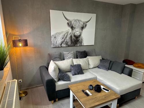 a living room with a couch with a picture of a bull at Ferienwohnung Amelie in Thale