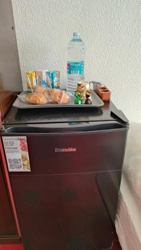 a plate of food and a bottle of water on top of a microwave at Pensión Benavente AP-7 3min coche Playa 5 min Self check-in 24h in Moncófar