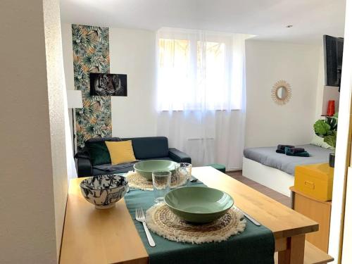 d'un salon avec une table et deux bols sur la table. dans l'établissement F1 tout équipé proche Tram - Jungle, à Mulhouse