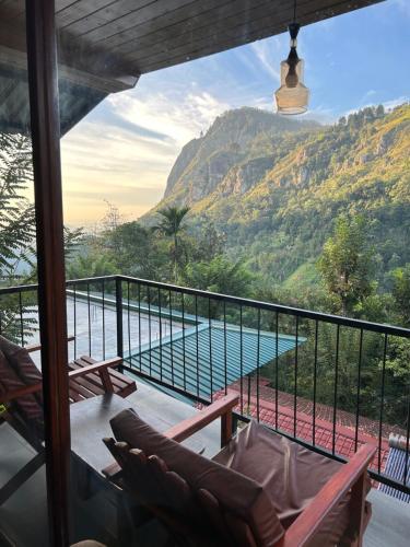 a balcony with chairs and a view of a mountain at Country Homes in Ella