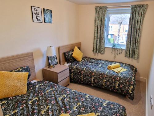 1 dormitorio con 2 camas y ventana en Luxury Spacious Apartment- Sleeps 4 Loughborough, en Loughborough