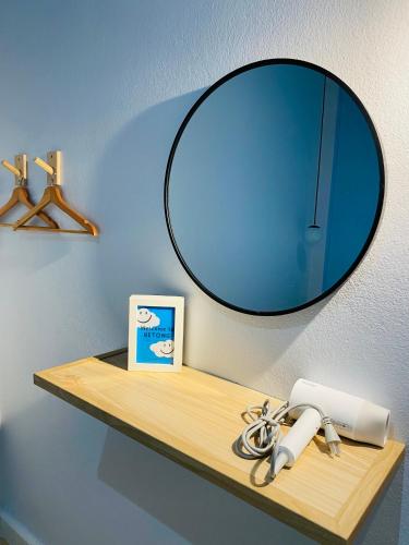 a mirror on top of a wooden shelf on a wall at FEEL LIKE HOME BETONG ฟีลไลค์โฮม เบตง in Betong
