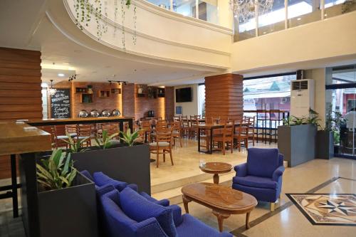 un restaurant avec des chaises et des tables bleues dans un bâtiment dans l'établissement Fersal Hotel Malakas, Quezon City, à Manille