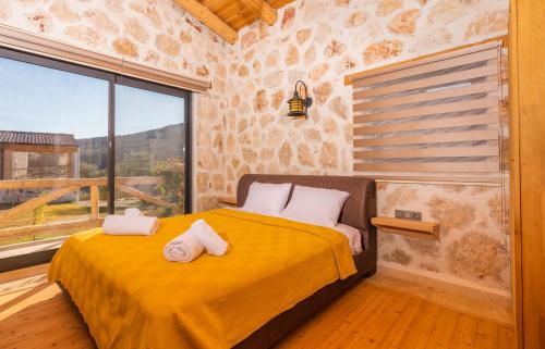 a bedroom with a yellow bed with a large window at Sedir Taş Evleri in Kalkan