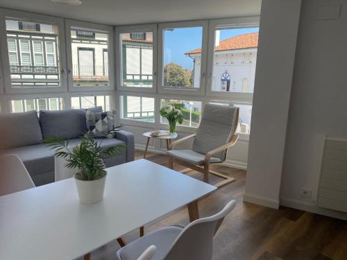 a living room with a couch and a table and chairs at APARTAMENTOS ARATUSTE - News a estrenar in Mundaka