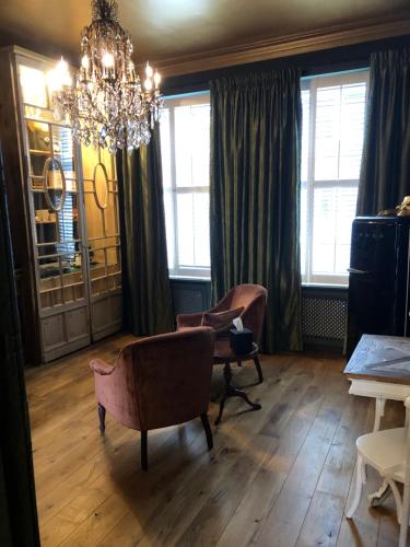 a living room with chairs and a chandelier at Sint Andries Suites in Antwerp