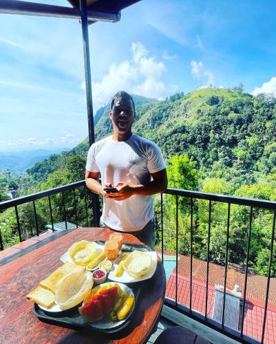 a man standing on a table with a tray of fruit at Country Homes in Ella