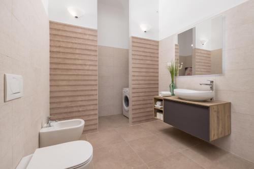 ein Badezimmer mit einem Waschbecken, einem WC und einem Spiegel in der Unterkunft Apartment Dana in Rijeka