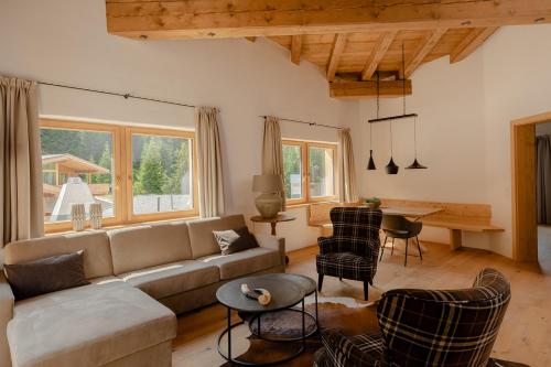 a living room with a couch and a table at das Chaletdorf - Pitztal in Sankt Leonhard im Pitztal