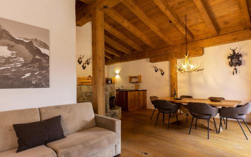 a living room with a couch and a table at das Chaletdorf - Pitztal in Sankt Leonhard im Pitztal