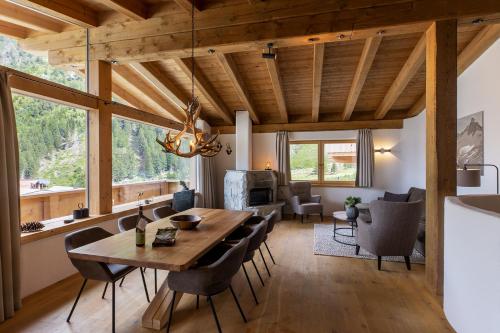 a dining room and living room with a table and chairs at das Chaletdorf - Pitztal in Sankt Leonhard im Pitztal