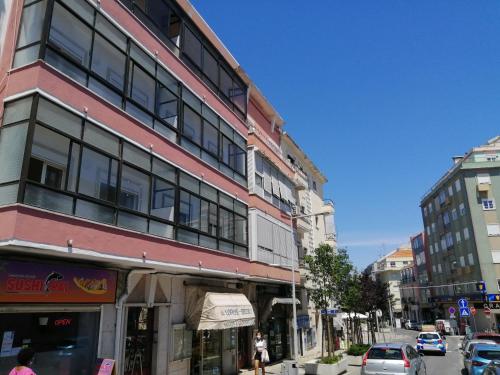un edificio alto en una calle de la ciudad con coches aparcados en Oriente DNA Studios V en Lisboa