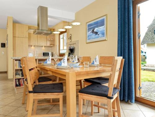 eine Küche und ein Esszimmer mit einem Holztisch und Stühlen in der Unterkunft Reethus Blinkfüer in Timmendorf