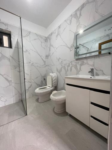 a bathroom with a toilet and a sink and a mirror at Vila Ani in Ksamil
