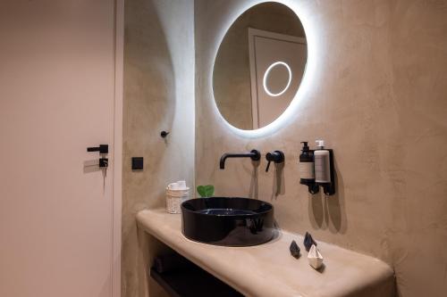 a bathroom with a sink and a mirror on the wall at Kalma Living Luxury Villas in Kithnos