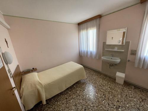 een ziekenhuiskamer met een bed en een wastafel bij Casa Caburlotto in Venetië