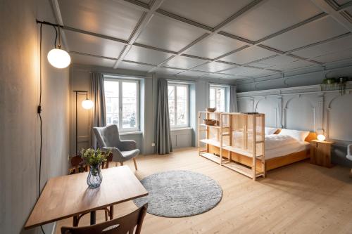 una camera con letto, tavolo e sedie di JACOB 1808. fine historic town apartments a Bischofszell