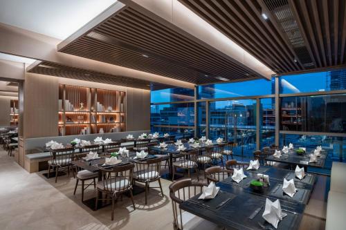 a restaurant with tables and chairs and a view of the city at Genpla Hotel, Shenzhen Qianhai in Shenzhen