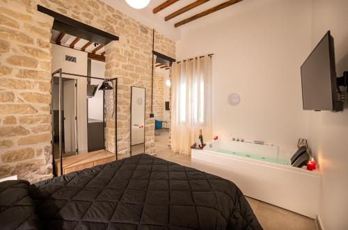 a bedroom with a bed and a tub in a room at Apartamentos Loliqui centro Alicante in Alicante