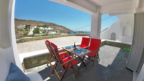 a table and chairs on a balcony with a view at 1Path Thea Mykonos Super Paradise Beach House in Mýkonos City