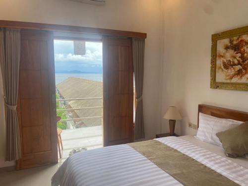 a bedroom with a bed and a large window at D'TRANSIT in Nusa Penida