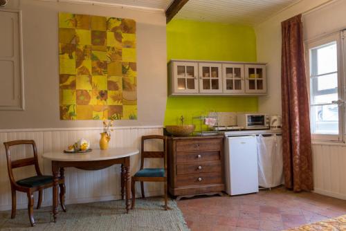 une cuisine avec une table et un réfrigérateur blanc dans l'établissement Mia Casa, à Arles