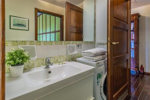 La salle de bains est pourvue d'un lavabo et d'un miroir. dans l'établissement Ca' Maria Lavanda by Wonderful Italy, à Bellagio