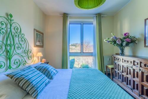 a bedroom with a blue bed and a window at Ca' Maria Lavanda by Wonderful Italy in Bellagio