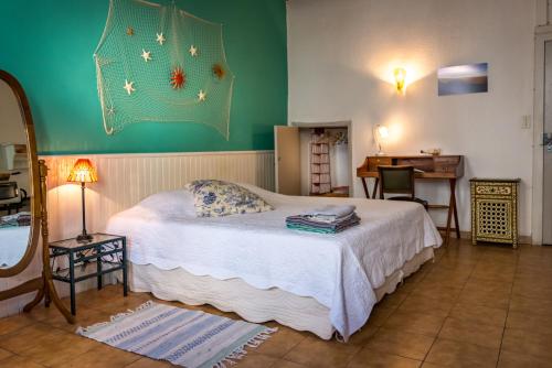 a bedroom with a bed with a green wall at Mia Casa in Arles