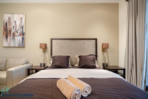una camera da letto con un letto e due asciugamani di ALH Vacay - Studio in Elite Downtown Residence a Dubai