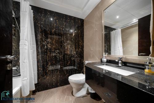 bagno con servizi igienici, lavandino e specchio di ALH Vacay - Studio in Elite Downtown Residence a Dubai