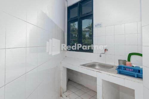 a bathroom with a sink and a window at Villa Puncak Agape near Cipanas Mitra RedDoorz in Cianjur