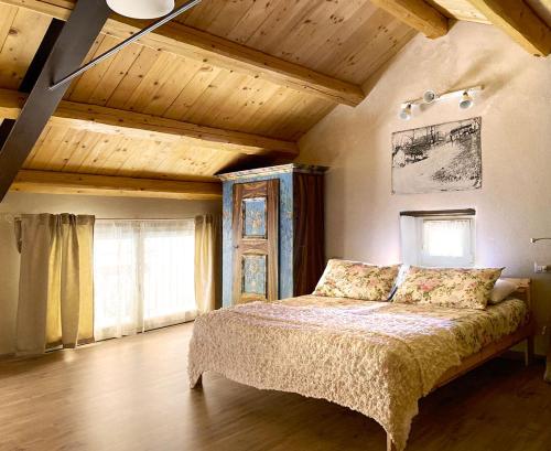 een slaapkamer met een bed en een houten plafond bij Casa del Piol Fattoria dei fiori in Sospirolo