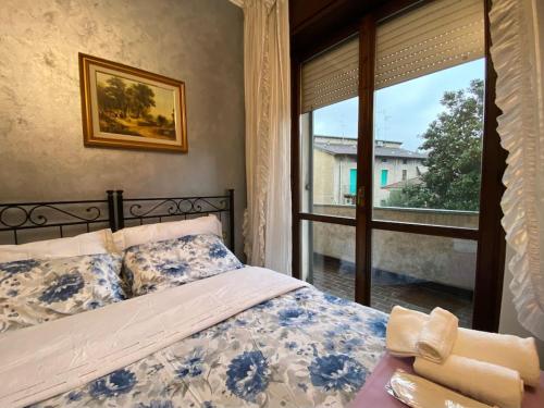 a bedroom with a bed and a large window at Fronte Fiera Apartment in Pero