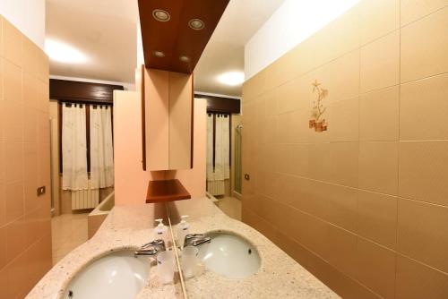 a bathroom with a sink and two faucets at Fronte Fiera Apartment in Pero