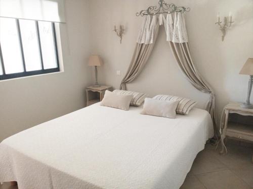 une chambre avec un lit blanc avec deux oreillers dans l'établissement Le Grand Barsan, à Vaison-la-Romaine