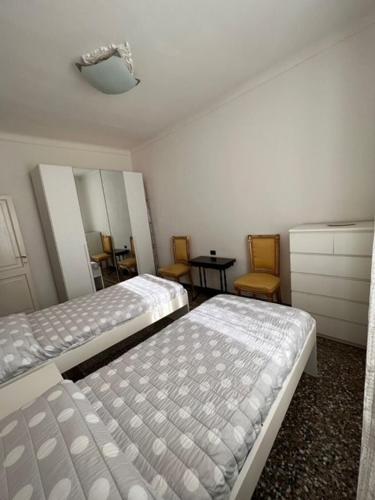 - une chambre avec deux lits, une commode et des chaises dans l'établissement CASA BALBI, à Gênes