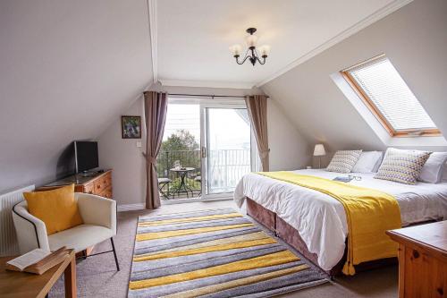 a bedroom with a bed and a chair and a window at Orchard House Wadebridge Self Catering in Wadebridge